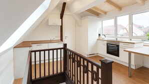 A modern kitchen with white cabinets, a wooden countertop, and a large window. - Lux Suites Leipzig Paradise Apartment (Leipzig)