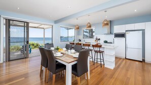A modern kitchen with white cabinets, a built-in oven, and a refrigerator.