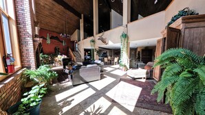 Eine großzügige Lobby mit hoher Decke, Kamin und einer Treppe zu den oberen Stockwerken.