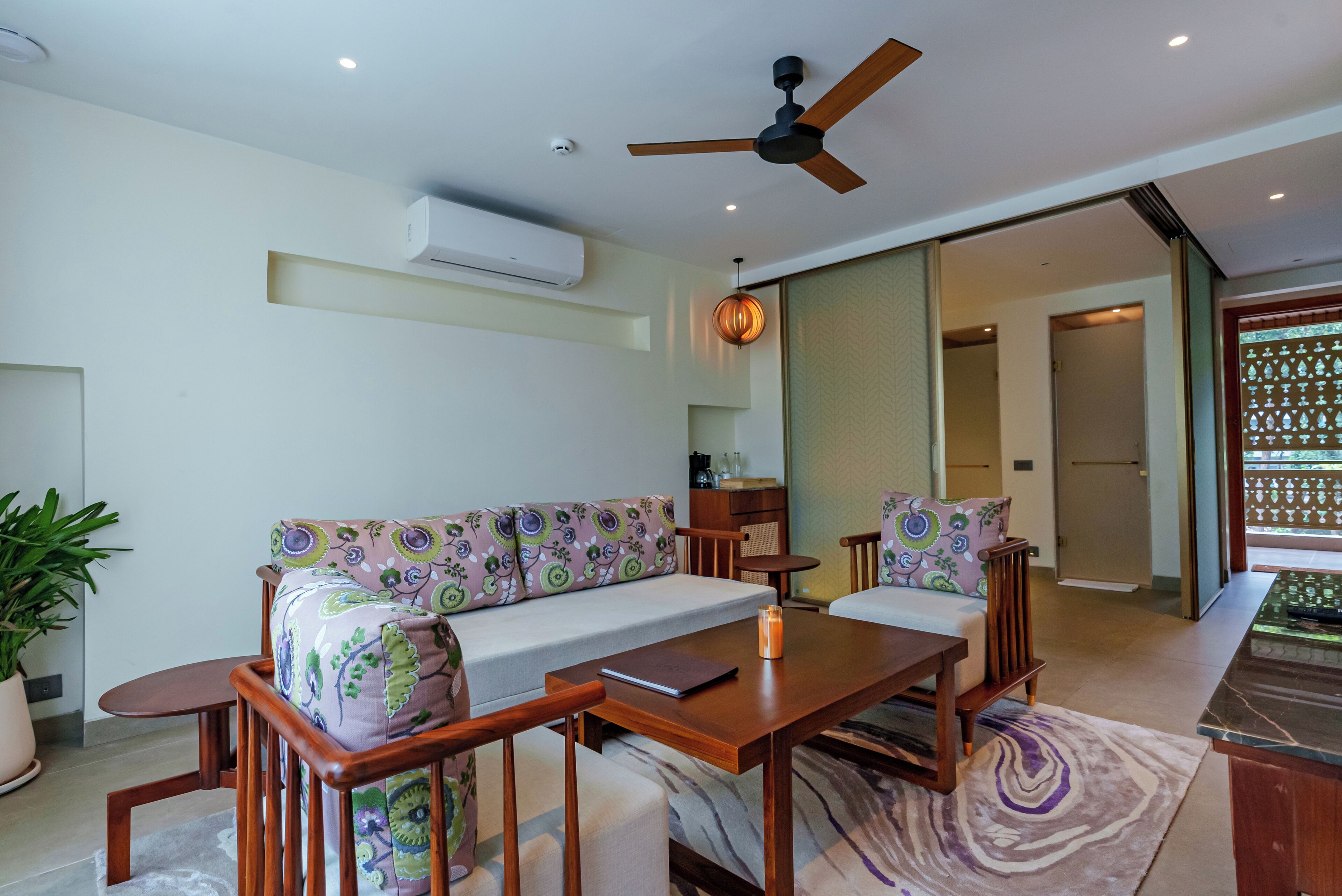 A modern living room with a sofa, wooden coffee table, and a ceiling fan.