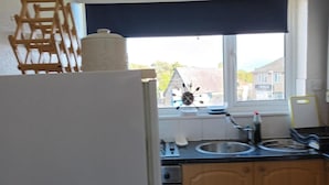 A kitchen with a window, a wooden ladder, a kettle, and a toaster. - Leeds - Apartment - Stay 3- Parking - Garden (Leeds)
