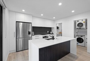 A modern kitchen with stainless steel appliances, a central island, and built-in appliances.