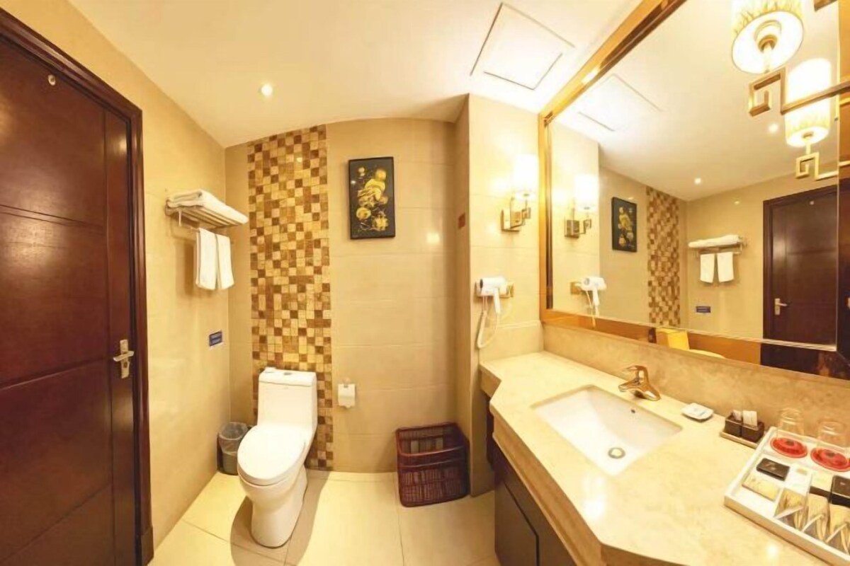 A compact bathroom with a toilet, sink, and mirror.