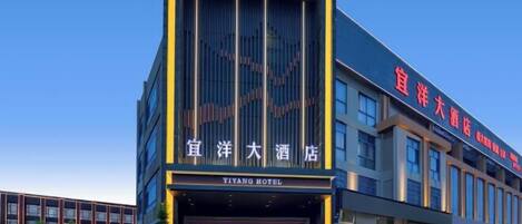 A modern hotel building with a prominent entrance and signage in both Chinese and English.