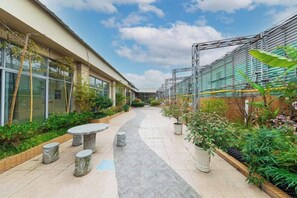 A courtyard with a pathway, seating area, and potted plants. - Yiyang Hotel (Yiling Wanda Plaza, Yichang Three Gorges Enterprise Base) (Yichang)
