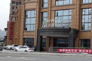 A multi-story building with a prominent sign for 'Sina Wellness' on the facade. - Yiyang Hotel (Yiling Wanda Plaza, Yichang Three Gorges Enterprise Base) (Yichang)