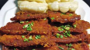 A plate with fried fish and corn on the cob.