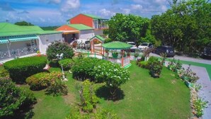 A hotel with a green roof, a gazebo, and a well-maintained garden. - Villa Ludivine 2 (Sainte-Anne, Guadeloupe)