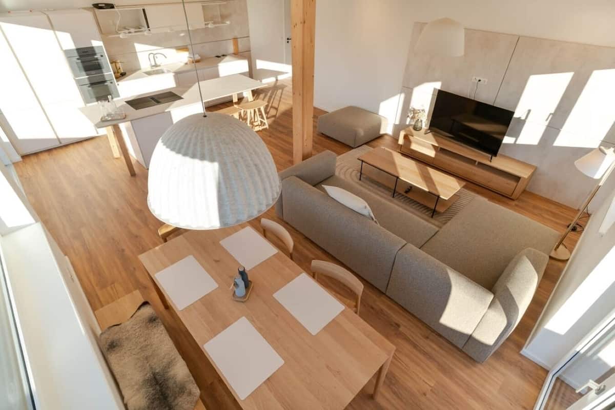 Un espace de vie moderne et compact comprenant une cuisine, un coin repas et un espace salon.