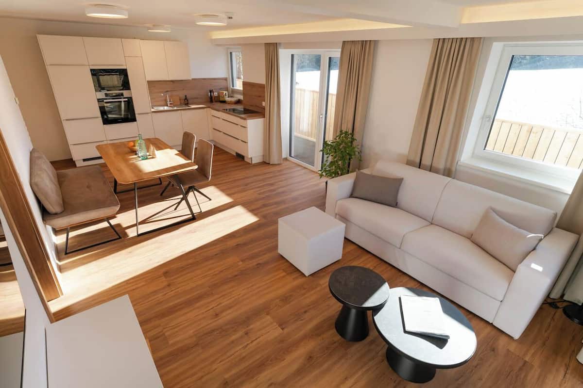 Un espace de vie moderne comprenant une cuisine, un coin repas et un espace détente.