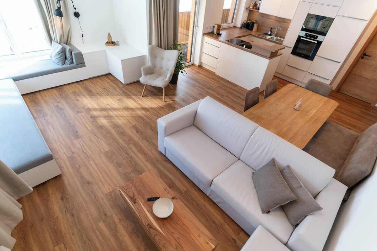 Un appartement moderne comprenant un salon, un canapé, une table à manger et un coin cuisine.