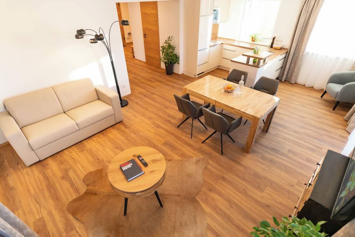 Un salon moderne comprenant un canapé, une table à manger avec des chaises, une table basse et un téléviseur.