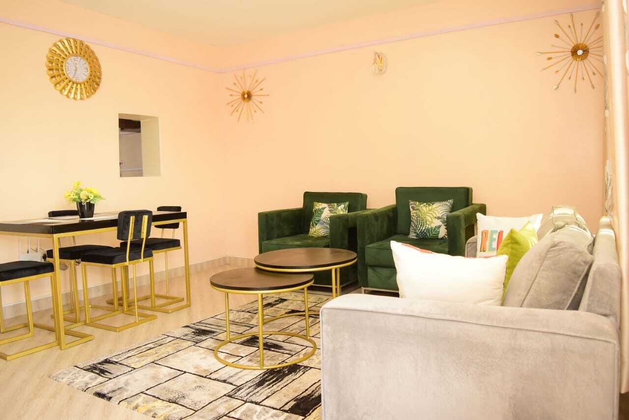 Una sala de estar moderna con un sofá, dos sillones, una mesa de comedor con sillas y relojes de pared decorativos.