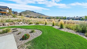 A residential area with houses, a well-maintained lawn, and a mountain in the background. - Mountain View Family Retreat w/ Hot Tub & Ski Access (Eden)