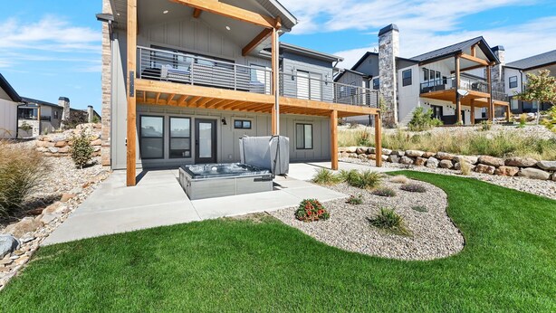 A modern two-story house with a patio, outdoor hot tub, and a landscaped garden. - Mountain View Family Retreat w/ Hot Tub & Ski Access (Eden)