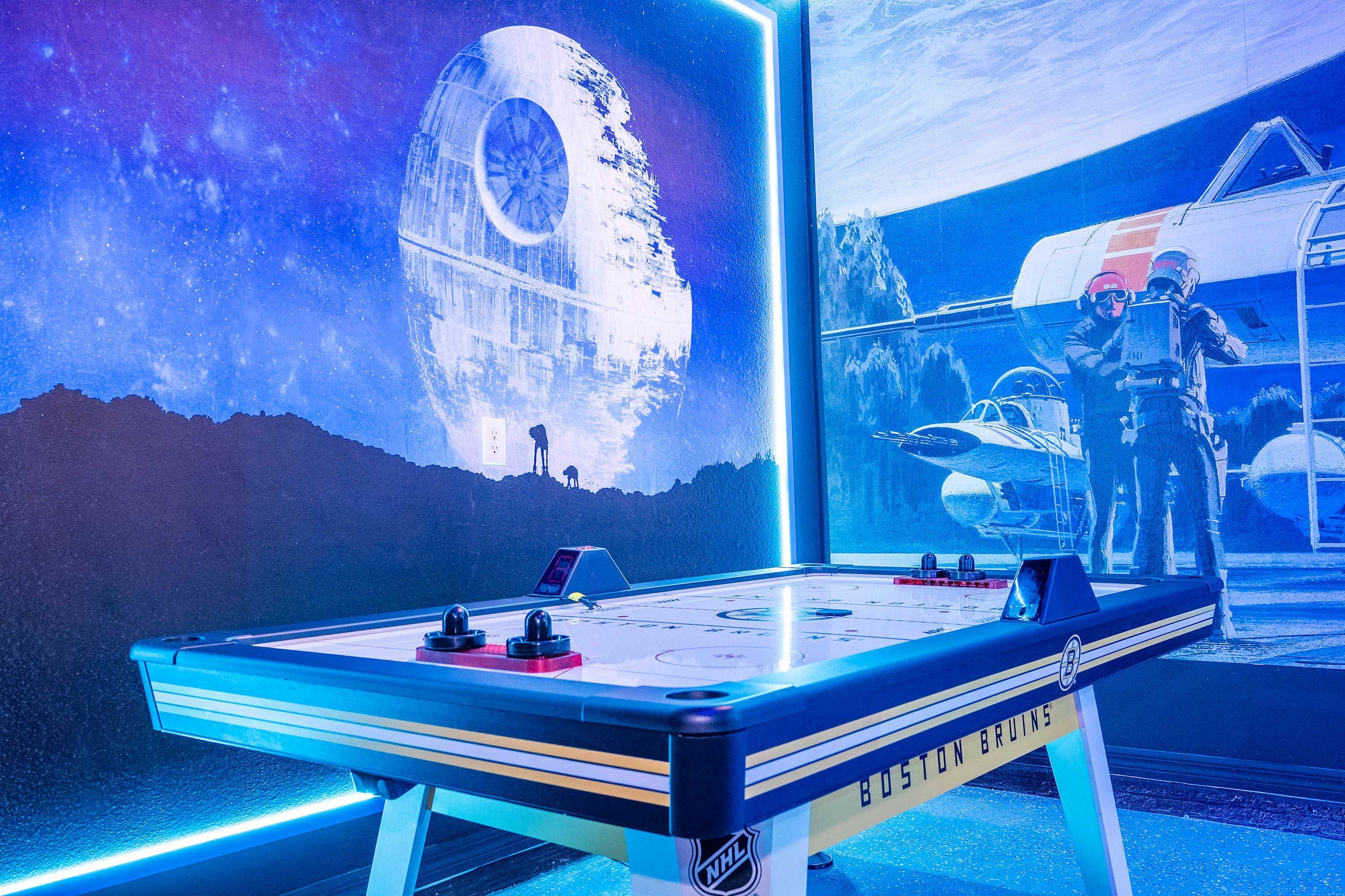 Una mesa de billar con un fondo alusivo a Star Wars, que incluye la Estrella de la Muerte y un avión de combate.