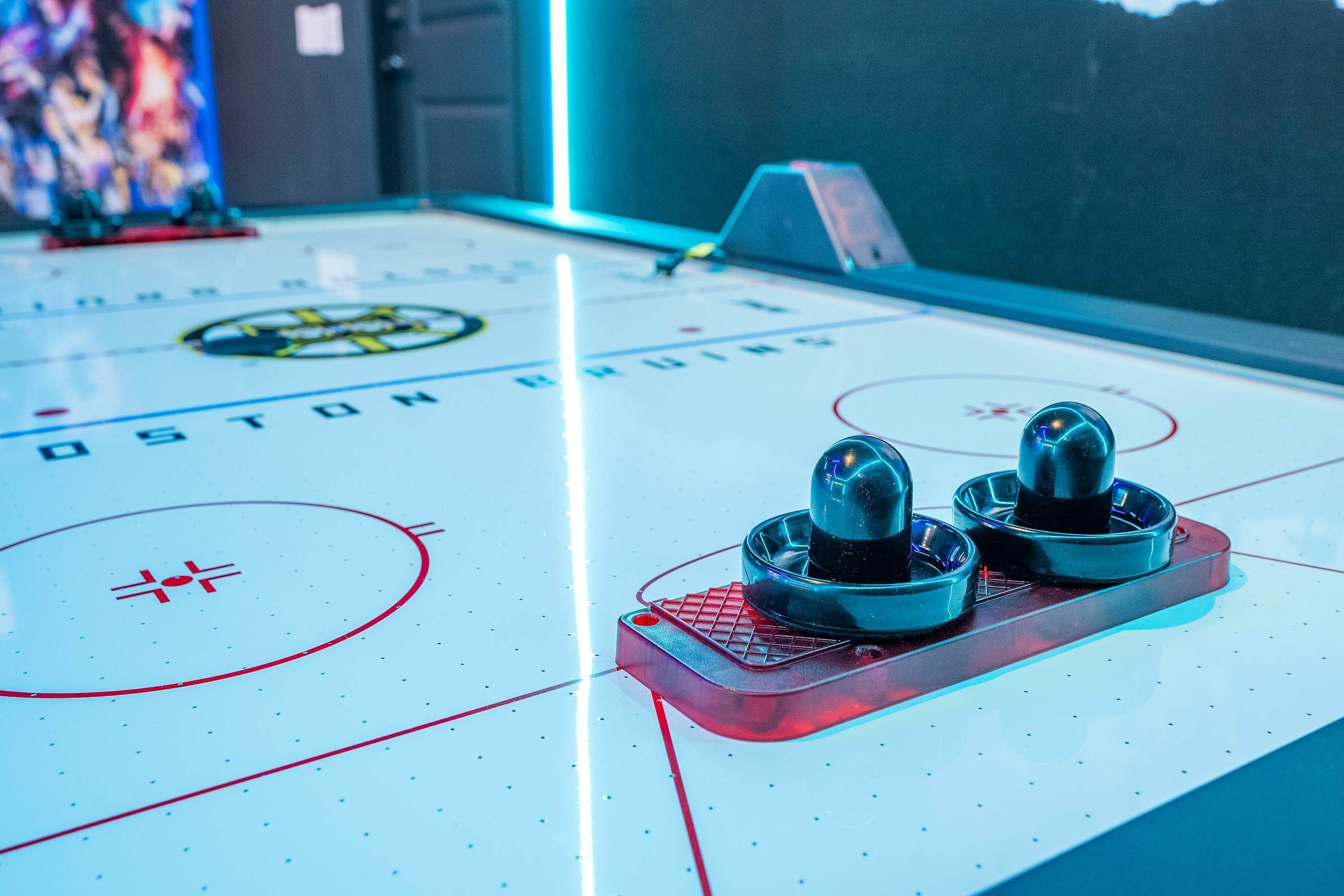 Primer plano de un juego de hockey sobre hielo con el logotipo de los Boston Bruins, dos discos y una portería.