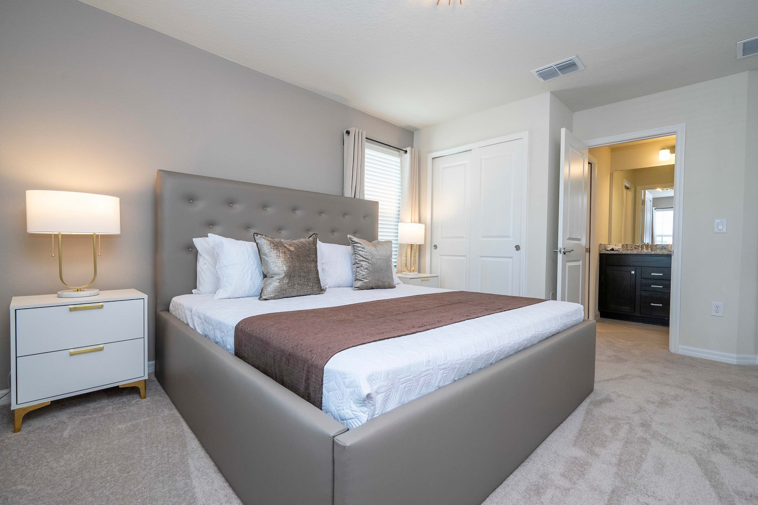 A bedroom with a large bed, two bedside tables, and a nightstand.