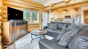 A log cabin interior with a living room, kitchen, and large TV. - Log Cabin w/ Wraparound Deck in Breckenridge! (Breckenridge)