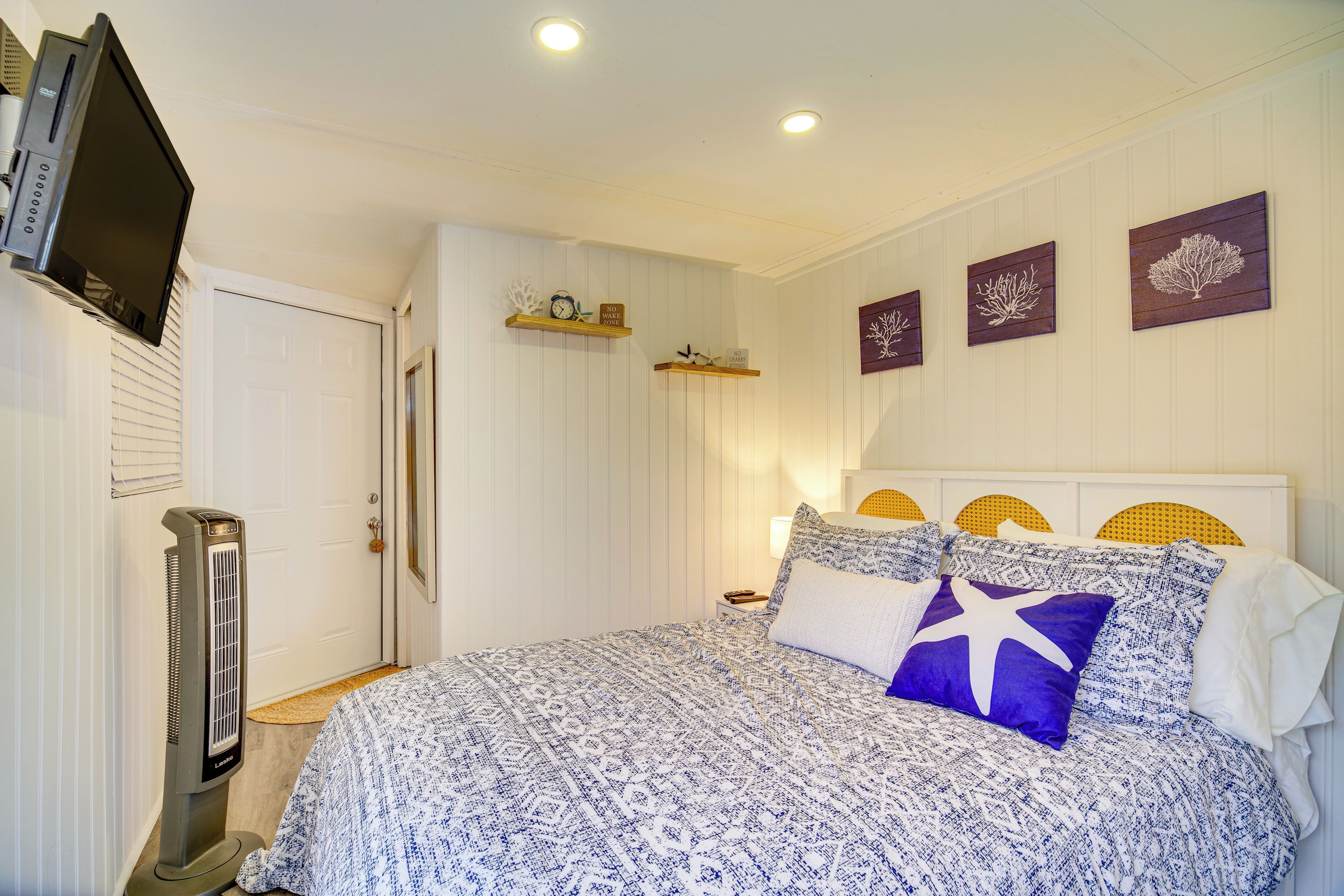 Une chambre à coucher comprenant un lit, un radiateur, un téléviseur et des décorations murales.