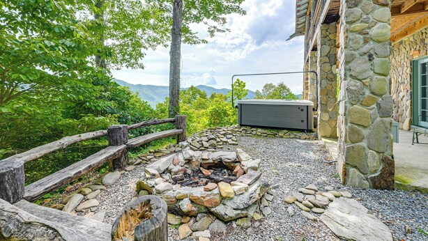 A stone building with a fire pit and a wooden fence. - Bryson City Cabin: Hot Tub + Mtn View! (Bryson City)