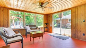 A room with wicker furniture, a ceiling fan, and large windows. - Home ~ 17 Mi to Detroit w/ Patio & Grill! (Southfield)