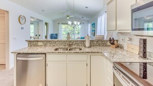 A modern kitchen with granite countertops, stainless steel appliances, and a central island. - Screened Porch & Community Perks: Myrtle Beach Gem (Myrtle Beach)
