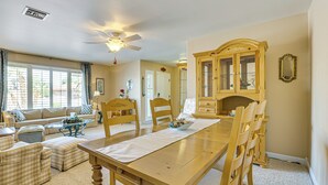 A dining area with a wooden table, chairs, and a cabinet. - Quiet Sun City West Home - Near Surprise Stadium! (Sun City West)
