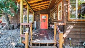 A wooden cabin with a red door, a covered porch, and a gravel pathway. - Idaho Family Home ~ 11 Mi to Lake Pend Oreille (Cocolalla)