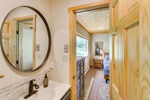 A bathroom with a large mirror, a sink, and a wooden cabinet. - Mountain-view Ranch w/ 200 Acres in Angel Fire (Angel Fire)
