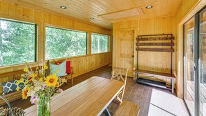A wooden cabin interior with a dining table, bench, and a bench with a backrest. - Mountain-view Ranch w/ 200 Acres in Angel Fire (Angel Fire)