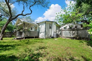 A single-story house with a covered porch and a fenced backyard.