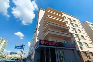 A multi-story hotel with a prominent sign indicating a restaurant on the ground floor.