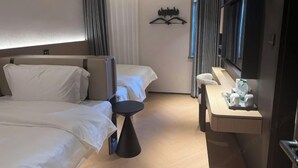 A hotel room with two beds, a desk with a chair, a flat-screen TV, and a mirror. - Youjian Hotel (Harbin Acheng Impression City) (Harbin)
