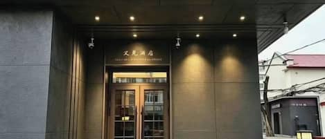Entrada de un edificio con puerta de vidrio y un letrero en la parte superior.