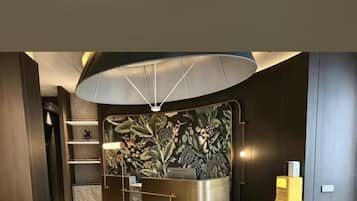 A reception area with a modern design, including a reception desk, a wall with a floral pattern, and a large overhead light fixture.