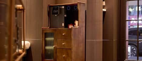 A hotel lobby with a wooden cabinet, a water dispenser, and a large window.