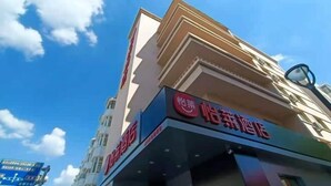 A hotel with a prominent red sign and a clear blue sky in the background.