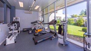 Una palestra con tapis roulant, cyclette e macchinari per l'allenamento con i pesi.