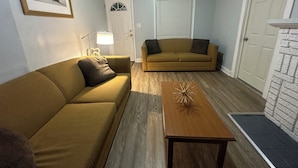 A living room with two sofas, a coffee table, a lamp, and a fireplace. - Cozy house in welcoming Cleveland with AC, WiFi (Cleveland)