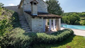 A stone house with a small porch and a pool. - Villa Zvonar in Karojba (Karojba)
