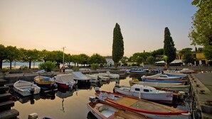 A marina with various boats docked, surrounded by trees and buildings. - Henry-historic Center 300mt From Lake (San Felice del Benaco)