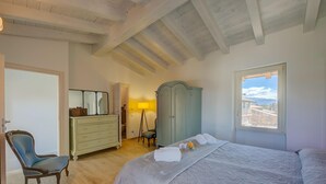 A bedroom with a bed, a chair, a dresser, a wardrobe, and a window with a view. - Henry-historic Center 300mt From Lake (San Felice del Benaco)