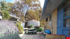 A backyard with a picnic table and chairs, a water tank, and a blue door. - Moorestone- Back to Yesteryear (Guilderton)