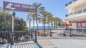 Une enseigne pour l’établissement Los Mellizos, avec vue sur la plage et les palmiers.