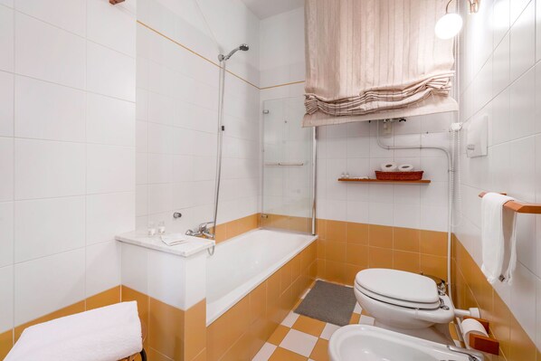 Un baño con bañera, inodoro y ducha.