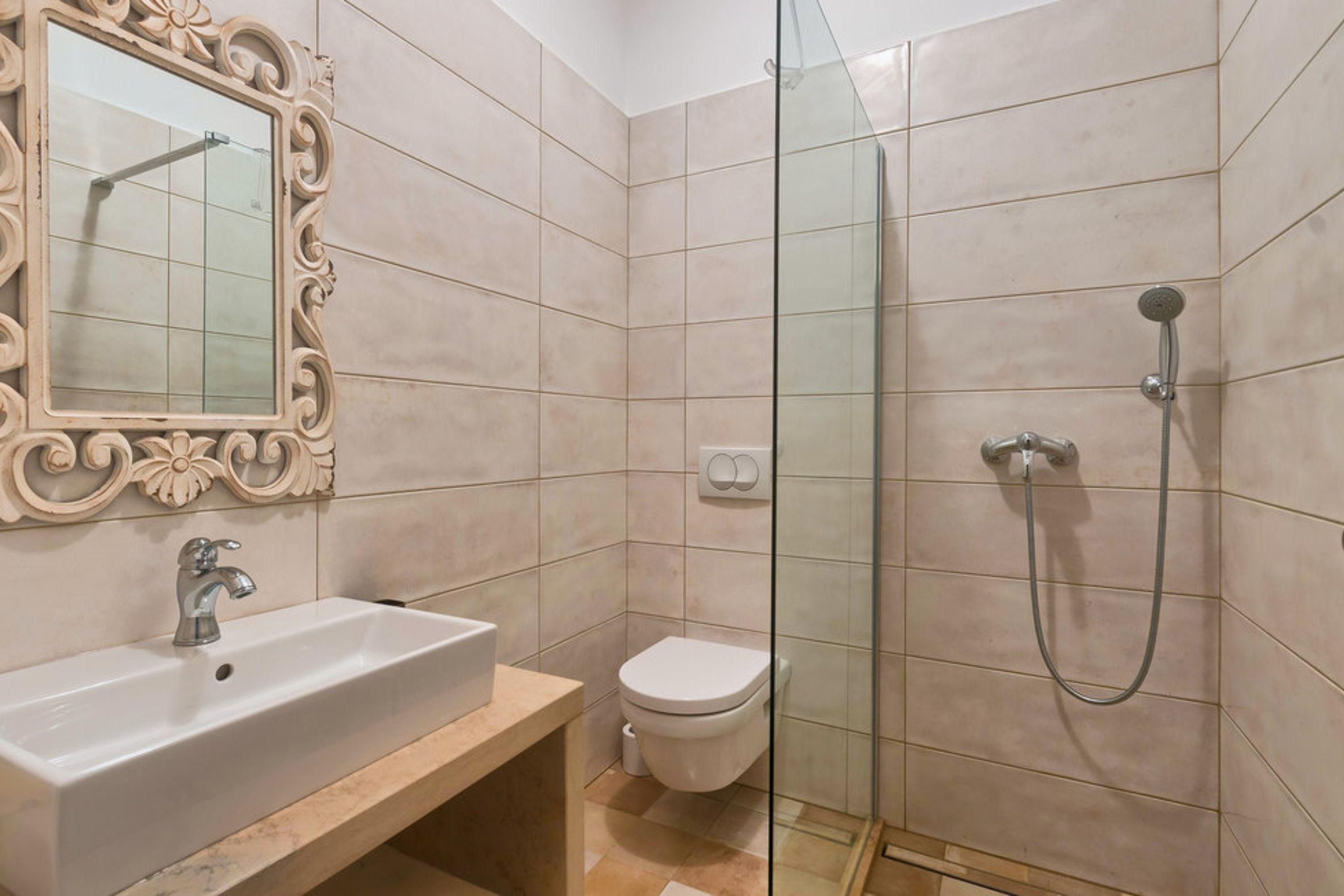 A bathroom with a sink, toilet, and glass-enclosed shower.
