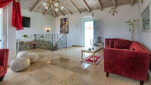 A spacious living area with a high ceiling, a red sofa, a coffee table, and a staircase with a railing. - Villa Lapis in Buzet (Buzet)