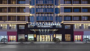 Un hôtel à plusieurs étages, doté d’une enseigne lumineuse indiquant « LA QUINTA BY WYNDHAM ».