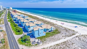 A coastal hotel with multiple blue buildings, a beach, and a road. - Beautiful, 2 Bed/2 Bath Pet Friendly Gulf Front Townhome at Portside Villas! (Pensacola Beach)
